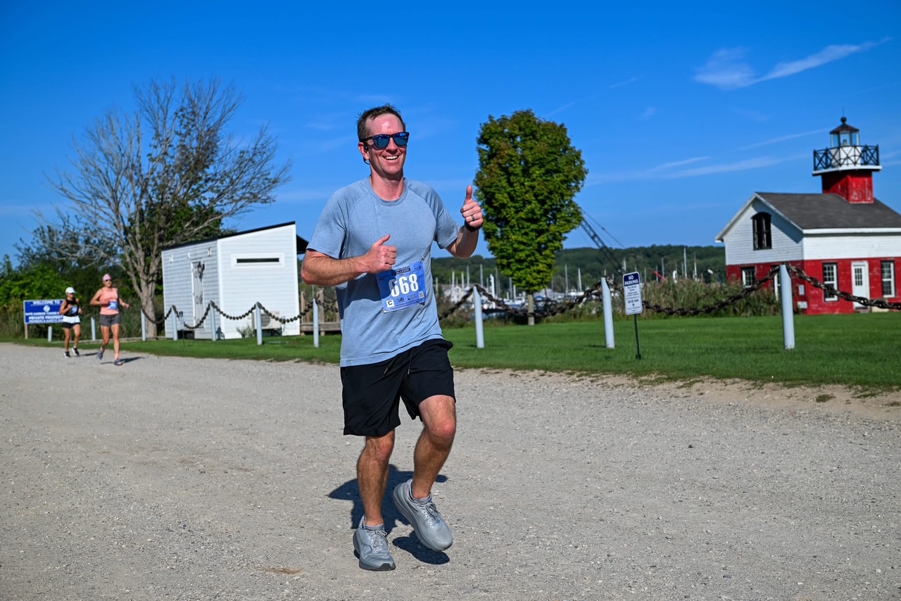 Austin running outdoors and smiling during a race